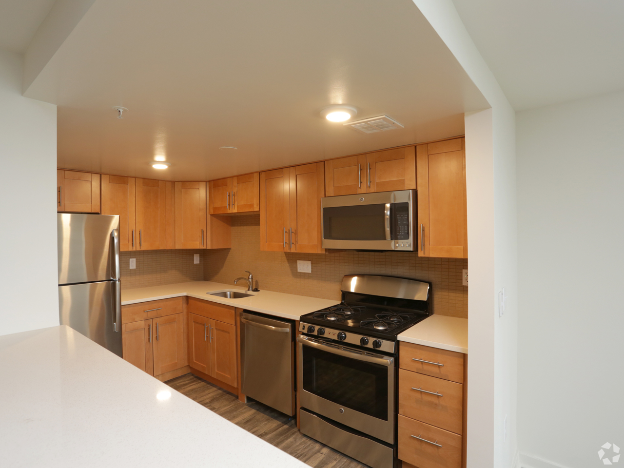 Interior view of wood kitchen finishes and stainless steel appliances.