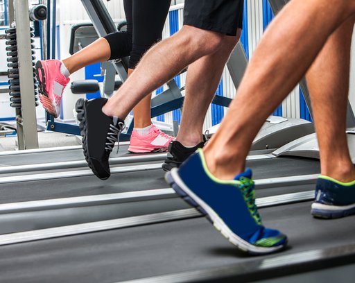 men and women running on treadmills in a gym